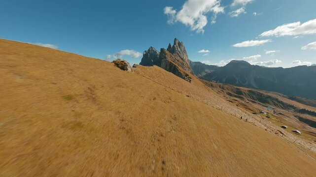 Smooth flight along the mountain range, filmed by FPV drone. Seceda, Italy