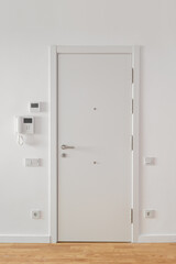 White entrance door with security features in a bright modern interior setting