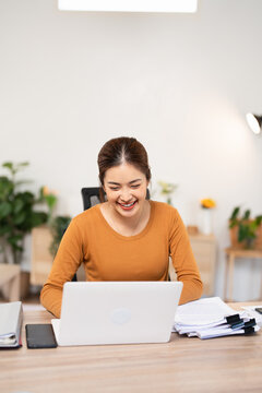 Pleasant happy young woman freelancer working on computer at home. Attractive businesswoman studying online, using laptop software, web surfing information or shopping in internet store.