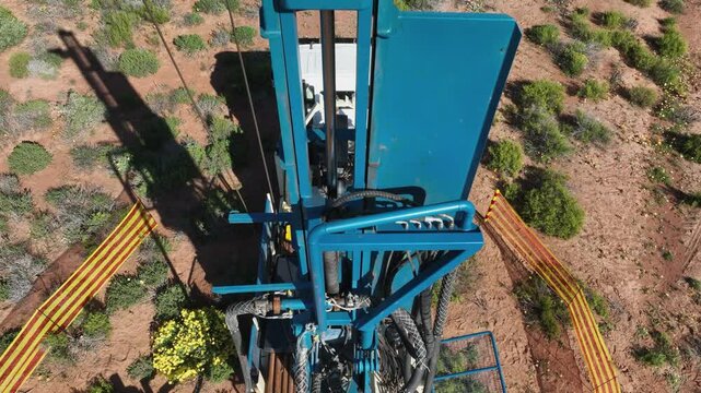 Close up aerial ascends tall blue steel derrick on mobile drilling rig