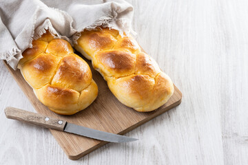 Traditional Easter braided bread. Tsoureki braid on white wooden table. Copy space