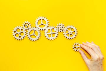 Hand is putting together cogwheels. Business automation and corporate work concept