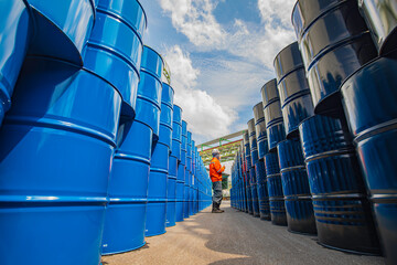 Male worker inspection record drum oil stock barrels blue vertical