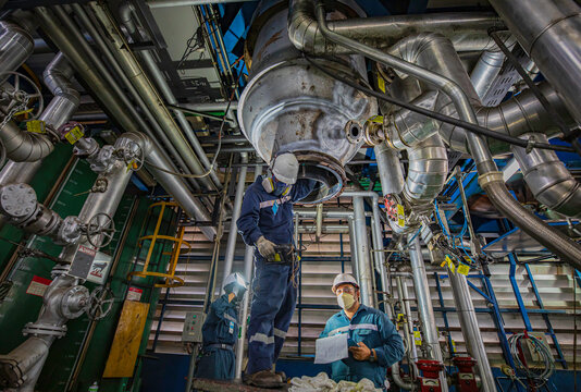 Male worker test stainless steel visual record paper butt weld carbon shell plate of storage tank - Powered by Adobe