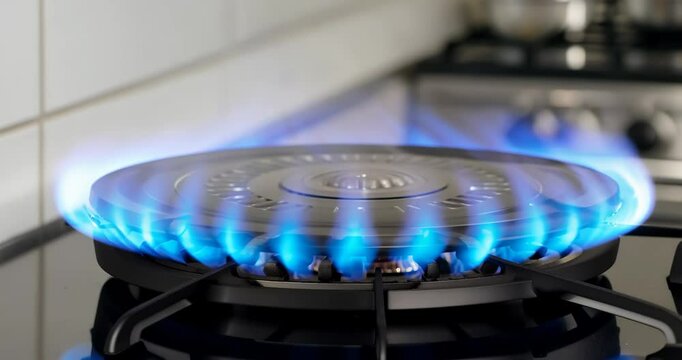 Cooking on gas stove with blue flames igniting circular burner