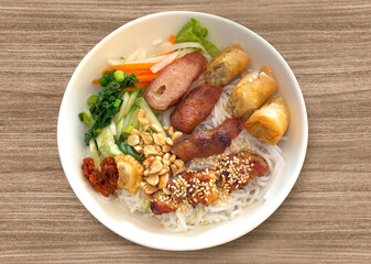 Bun thit nuong. A bowl of Vermicelli Noodles with Grilled Pork and Egg Rolls, Vietnamese grilled pork and rice noodles. Fried Spring Rolls Cold Rice Vermicelli with sauce served in bowl isolated.	