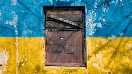 wall with the national colors of the flag of Ukraine and a boarded up window
