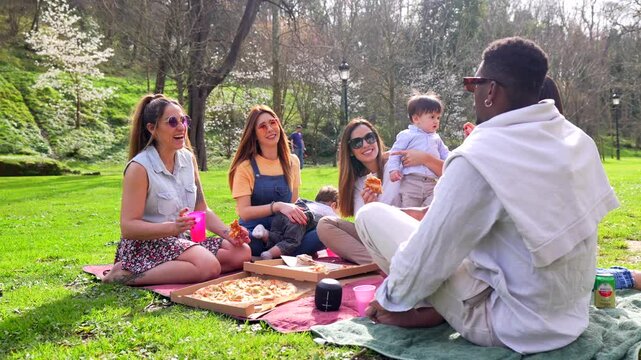 Friends enjoying pizza picnic in the park