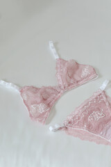 Woman's silk erotic lingerie on the white bed sheets. Valentine's day concept. Lace sexy female underwear. Beauty, fashion blogger concept. Female bra, panties, erotic clothes. Lingerie advertising