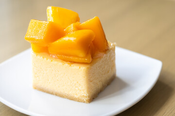mango cheese cake with fresh mango on white plate