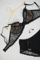 Woman's silk erotic lingerie on the white bed sheets. Valentine's day concept. Lace sexy female underwear. Beauty, fashion blogger concept. Female bra, panties, erotic clothes. Lingerie advertising