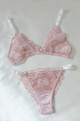 Woman's silk erotic lingerie on the white bed sheets. Valentine's day concept. Lace sexy female underwear. Beauty, fashion blogger concept. Female bra, panties, erotic clothes. Lingerie advertising