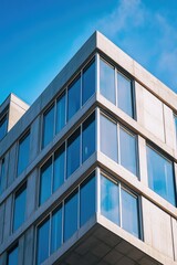 A tall, rectangular modern skyscraper featuring concrete facade and numerous rectangular windows. Office or business center building in cityscape.
