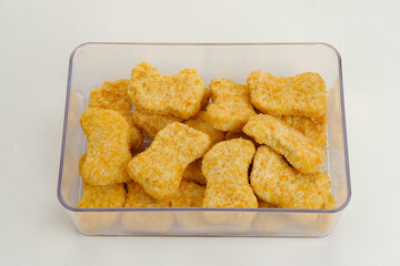 Homemade raw fried chicken nuggets on food container, frozen food preparation 
