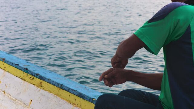 Traditional Handline Fishing at Sea in slow motion. Fisherman Using Handline to Catch Fish. Skilled Fisherman Pulling Line by Hand