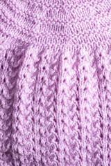 Fototapeta premium Fragment of hand knitted fabric light lilac. Vertical photo