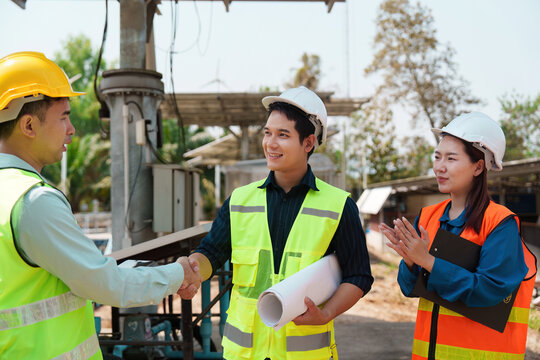 Agreement and Sustainable Practices. Professionals celebrating a successful agreement on solar energy projects.