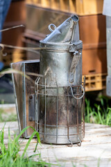 Apiculture - enfumoir posé sur une ruche pendant une visite sanitaire d'un rucher par l'apiculteur.