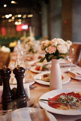 A beautiful bouquet of white roses decorates the festive table.