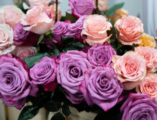 Bouquet of flowers from roses of different colors. Pink and purple roses.