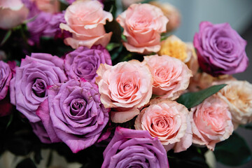 Bouquet of flowers from roses of different colors. Pink and purple roses.