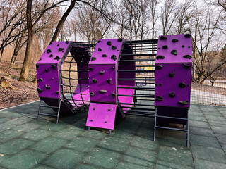 Colorful climbing structure in an outdoor playground surrounded by trees