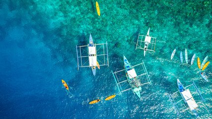 Aerial Top View of Bangka Boats as sand beach  by a crystal clear water. Entalula island, Bacuit Bay, El Nido, Palawan, Philippines.