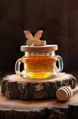 Organic natural Honey in glass jar with wooden honey dipper rustic style.