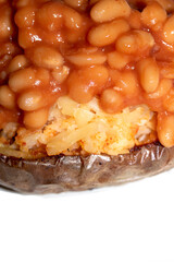 Close up of loaded jacket potatoe with tomato baked beans on top with white background