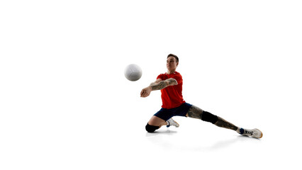 Fototapeta premium Competitive young man, volleyball player during match, playing with focus and motivation to win against white background. Concept of sport, competition, energy, active lifestyle, determination.