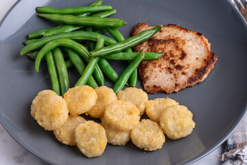 boneless pork chop with green beans and potato crowns