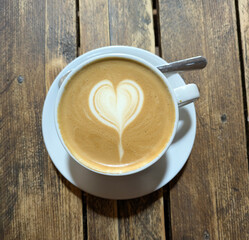 Close Up of an Oat Milk Latte Coffee in White Cup on a Rustic Wooden Table Background with Love Heart