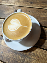 Close Up of an Oat Milk Latte Coffee in White Cup on a Rustic Wooden Table Background with Love Heart
