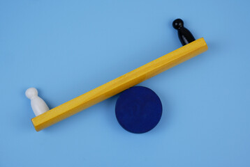 White figure of a man outweighs black one on scales. Inequality of races of people and injustice concept.