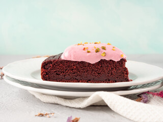 Piece of beetroot chocolate cake with pink cream cheese icing