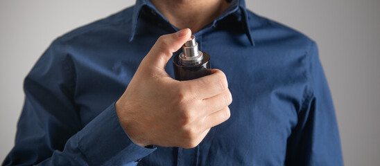 Caucasian man with a bottle of perfume. Beauty. Fashion