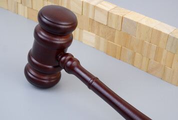 Judge gavel near wooden wall on gray background. Legal protection and safety concept.