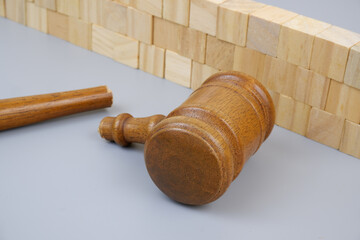 Broken judge gavel near wooden wall. Injustice and lawlessness concept.