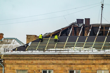 Fototapeta premium Repair of the roof of an old house. Replacement of the roof covering of a building