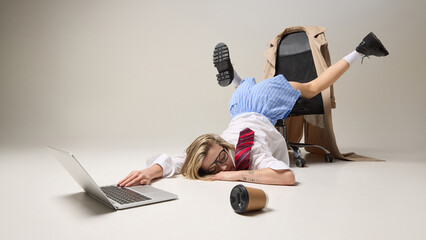Exhausted woman collapsed in unconventional pose on office chair against white background, and...