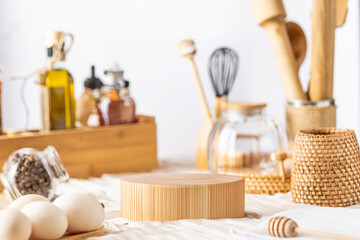 Wooden podium stand in a rustic still life with wooden kitchen inventory in woven containers, a cutting board with eggs, oil and a small jar of peppercorns
