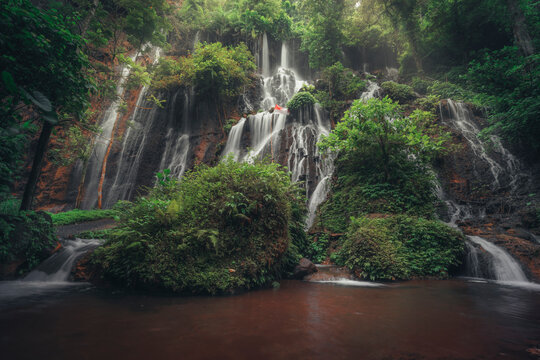 View of Goa Tetes waterfall cascading through lush greenery in a serene forest, Pronojiwo, Lumajang, East Java, Indonesia.