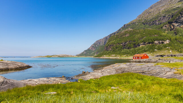 View of picturesque fishing house by the serene bay and tranquil ocean, Mjeldevika, Bodo, Fylke Nordland, Norway.