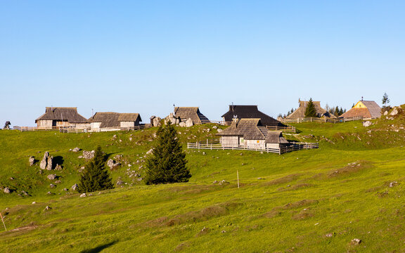 View of idyllic alpine pasture with rustic cabins and mountain huts in a serene mountain landscape, Velika Planina, Kamnik, Slovenia.