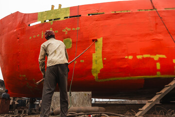 Dhaka, Bangladesh - 18 February 2025: View of shipyard with workers painting and repairing vessels, Dhaka, Dhaka Province, Bangladesh.