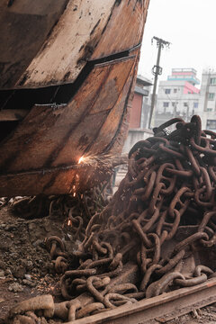 Dhaka, Bangladesh - 18 February 2025: View of a bustling shipyard with rusty chains and sparks flying, Dhaka, Dhaka Province, Bangladesh.