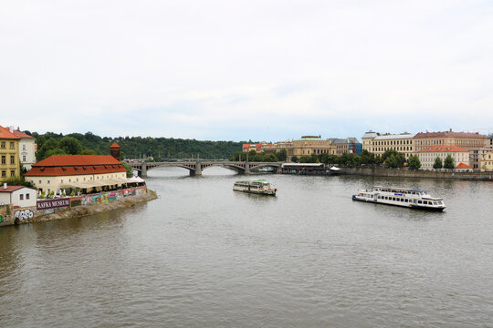 Fototapeta Prague, Czech Republic - 31 July 2016: View of the beautiful Prague Moldau river with historic buildings and a scenic bridge, Prague, Czech Republic.