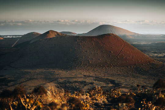 View of majestic volcanic landscape at sunset with rugged peaks and a barren crater, Fuente de Montana Negra, Lanzarote, Spain.