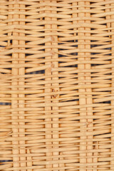 A close-up shot of woven rattan with a visible underlying fabric, creating a textured pattern