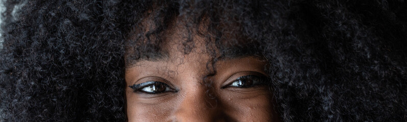 Close-up of young woman with afro hair showing expressive eyes